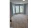 A sunlit bedroom with plush carpet, light gray walls, and a bay window offering lovely views at 1925 Cedar Walk Ln, Conley, GA 30288