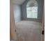 Bedroom featuring a large arched window allowing abundant natural light and neutral carpet, providing a welcoming space at 1925 Cedar Walk Ln, Conley, GA 30288