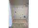 A compact laundry room with tile floors, washer/dryer hookups, and a shelf for storage at 1925 Cedar Walk Ln, Conley, GA 30288