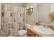 Well-lit bathroom featuring vanity, toilet, and shower with decorative shower curtain at 7813 Newbury Dr, Jonesboro, GA 30236