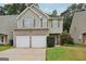 Charming two-story home with a two-car garage, neutral siding and brick accents, complimented by mature landscaping at 7813 Newbury Dr, Jonesboro, GA 30236