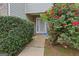 Inviting entryway with a well-manicured hedge and vibrant red roses leading to a white, decorative front door at 7813 Newbury Dr, Jonesboro, GA 30236