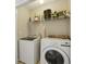 A laundry room featuring a white washer and dryer, plus overhead storage shelves at 7813 Newbury Dr, Jonesboro, GA 30236