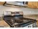 Close-up of a modern stainless steel oven featuring a stovetop and digital display at 7813 Newbury Dr, Jonesboro, GA 30236