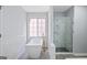 Modern bathroom featuring soaking tub, gold fixtures, glass shower with marble accents at 984 Wenham Ln, Lawrenceville, GA 30044