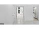 Bright hallway with white walls, porcelain tile floors and access to a kitchen at 984 Wenham Ln, Lawrenceville, GA 30044