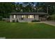 Charming, renovated brick ranch on a lush lot with a carport at dusk, offering curb appeal at 30 Mary Ella Dr, Carrollton, GA 30116