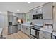 This is a kitchen with stainless steel appliances, gray cabinets, quartz countertops, and modern backsplash at 30 Mary Ella Dr, Carrollton, GA 30116
