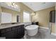 A luxurious bathroom featuring dual sinks, an elegant soaking tub, and stylish tile flooring at 108 Donovan Ave, Locust Grove, GA 30248