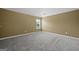An empty bedroom featuring neutral walls, plush carpeting, and a window that fills the room with light at 108 Donovan Ave, Locust Grove, GA 30248