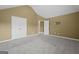 An empty bedroom featuring neutral walls, plush carpeting, doors to closet and access to more living space at 108 Donovan Ave, Locust Grove, GA 30248