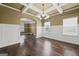 Elegant dining room featuring hardwood floors, wainscoting, and a coffered ceiling with modern chandelier at 108 Donovan Ave, Locust Grove, GA 30248