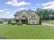 Charming two-story home with a well-manicured lawn and lush landscaping at 108 Donovan Ave, Locust Grove, GA 30248