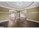 Open-concept living room with hardwood floors, archways, and a view of the staircase at 108 Donovan Ave, Locust Grove, GA 30248