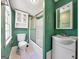 Green bathroom featuring a toilet, shower, and white vanity at 927 Dean Patrick Rd, Locust Grove, GA 30248