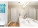 Bright bathroom with a double vanity, decorative faucets, a large mirror, and a shower at 2600 Neighborhood Walk, Villa Rica, GA 30180