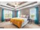 Inviting bedroom with tray ceilings, a ceiling fan, and large windows with views at 2600 Neighborhood Walk, Villa Rica, GA 30180