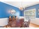 Classic dining room featuring a wood table, chandelier, blue accent wall, and decorative sideboard at 2600 Neighborhood Walk, Villa Rica, GA 30180