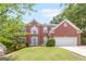 Charming two-story brick home with a manicured front lawn and an attached two-car garage at 2600 Neighborhood Walk, Villa Rica, GA 30180