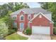 Two-story brick home featuring a well-manicured lawn and a light blue front door, inviting entrance and attached garage at 2600 Neighborhood Walk, Villa Rica, GA 30180