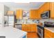 Well-lit kitchen with wooden cabinetry, stainless steel appliances and a kitchen island at 2600 Neighborhood Walk, Villa Rica, GA 30180
