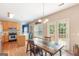 Bright kitchen with wood cabinets, stainless appliances, a kitchen island, and dining area with a door to outside at 2600 Neighborhood Walk, Villa Rica, GA 30180