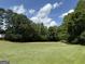 Lush backyard with mature trees and ample green space, offering privacy and a natural setting at 410 Clubland Se Cir, Conyers, GA 30094