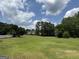 Expansive backyard with lush green grass, mature trees, and a white picket fence, perfect for outdoor activities at 410 Clubland Se Cir, Conyers, GA 30094