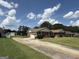 Single-story brick house with a two-car garage and a long driveway under a cloudy blue sky at 410 Clubland Se Cir, Conyers, GA 30094