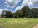 Expansive grassy lot surrounded by mature trees, offering privacy and a natural setting at 410 Clubland Se Cir, Conyers, GA 30094