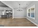 Dining area with modern chandelier and kitchen view, complemented by natural light from a large window at 296 Deer Creek Run # 11, Moreland, GA 30259