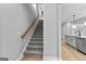 Carpeted staircase with wooden handrail leading to the upper level of the home near the kitchen at 296 Deer Creek Run # 11, Moreland, GA 30259