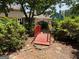 Backyard features a charming red footbridge surrounded by greenery and mature trees at 404 Windsor Way, Peachtree City, GA 30269