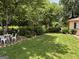 A lush green backyard featuring a patio table with chairs and manicured landscaping at 404 Windsor Way, Peachtree City, GA 30269