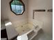Relaxing bathtub with tile surround and octagon window offering natural light and charm at 404 Windsor Way, Peachtree City, GA 30269