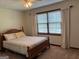 Comfortable bedroom with a wooden bed frame, natural light from the window, and carpet flooring at 404 Windsor Way, Peachtree City, GA 30269