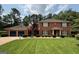 Charming brick home featuring a two-car garage, manicured lawn, and traditional design with blue shutters at 404 Windsor Way, Peachtree City, GA 30269
