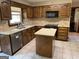 The kitchen features wooden cabinetry, an island with quartz countertops, and tile floors at 404 Windsor Way, Peachtree City, GA 30269