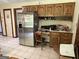 The kitchen features wooden cabinetry, stainless steel appliances, and tile floors at 404 Windsor Way, Peachtree City, GA 30269