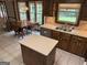 This kitchen features wooden cabinetry, an island with quartz countertops, and tile floors at 404 Windsor Way, Peachtree City, GA 30269