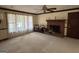 Cozy living room featuring a brick fireplace, large window, and neutral carpet at 404 Windsor Way, Peachtree City, GA 30269
