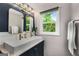 Modern bathroom featuring a double sink vanity, stylish fixtures, and a window with natural light at 1981 Shalimar Ne Dr, Atlanta, GA 30345