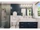 Stylish bathroom featuring dual mirrors, modern vanity with gold accents and a glass enclosed shower with rainfall showerhead at 1981 Shalimar Ne Dr, Atlanta, GA 30345