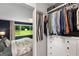 Spacious walk-in closet with custom shelving and storage solutions, adjoining a bedroom with a backyard view at 1981 Shalimar Ne Dr, Atlanta, GA 30345