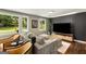 Comfortable living room featuring hardwood floors, a large grey couch, tan leather chairs and a modern TV at 1981 Shalimar Ne Dr, Atlanta, GA 30345