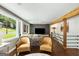 Comfortable living room featuring hardwood floors, a large grey couch, tan leather chairs and a modern TV at 1981 Shalimar Ne Dr, Atlanta, GA 30345