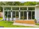 Bright sunroom features wall-to-wall windows, modern furniture, and a charming outdoor seating area at 1981 Shalimar Ne Dr, Atlanta, GA 30345