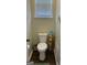Small bathroom with a white toilet, storage shelf, a window, and neutral wall color at 3955 Sweetwater Pkwy, Ellenwood, GA 30294