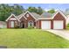 Charming red brick home features a two-car garage and a well-manicured front lawn at 3955 Sweetwater Pkwy, Ellenwood, GA 30294