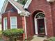 Close-up view of home's exterior with a red brick facade and manicured landscaping at 3955 Sweetwater Pkwy, Ellenwood, GA 30294